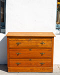 Antique three drawer oak dresser with paneled sides and brass ring pulls