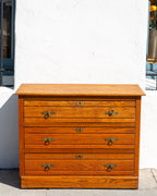 Antique three drawer oak dresser with paneled sides and brass ring pulls