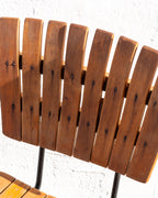 Detail of the eight rounded wood slats forming the back of a mid century bar stool