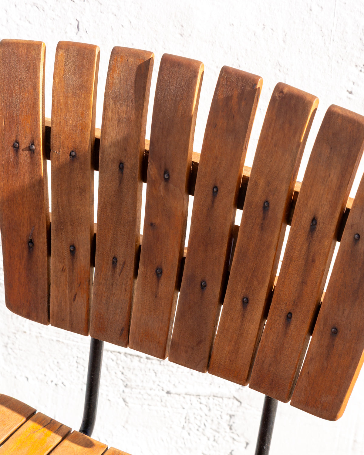 Detail of the eight rounded wood slats forming the back of a mid century bar stool