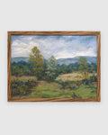 Straight-on view of a Sheila Beckley English landscape painting with autumn trees, meadow and blue hills in a striped wood frame, on a light gray background.