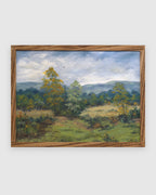 Straight-on view of a Sheila Beckley English landscape painting with autumn trees, meadow and blue hills in a striped wood frame, on a light gray background.