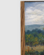 Side view of the frame edge on the Sheila Beckley English landscape painting with autumn trees, meadow and blue hills in a striped wood frame.