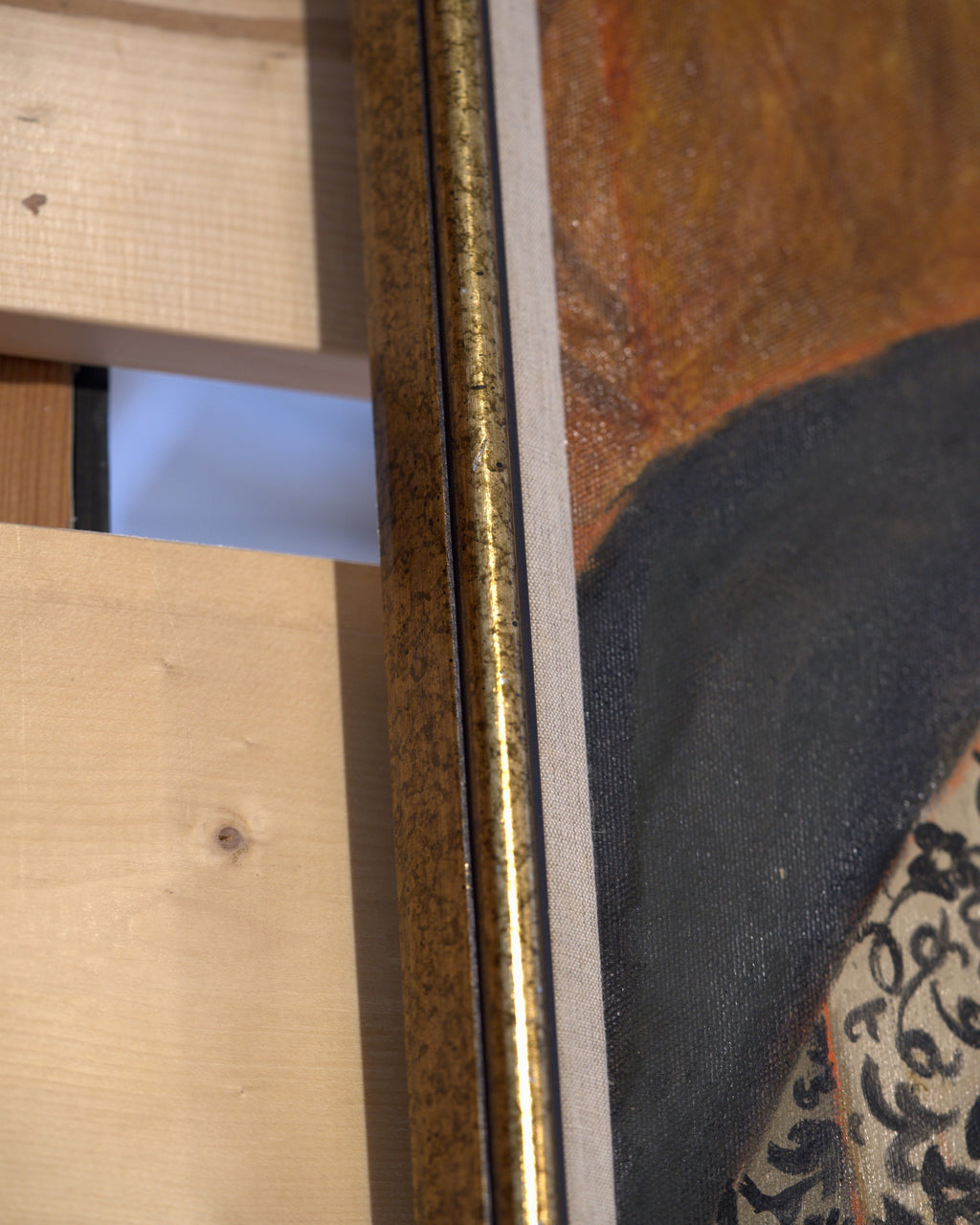 Side view of the frame edge on the Priscilla Bender-Shore 1963 self portrait in a navy jacket and beaded necklace on burnt orange, in a gilt frame.