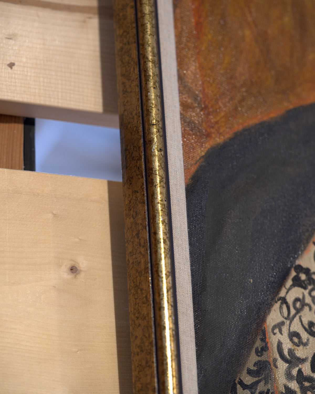 Side view of the frame edge on the Priscilla Bender-Shore 1963 self portrait in a navy jacket and beaded necklace on burnt orange, in a gilt frame.