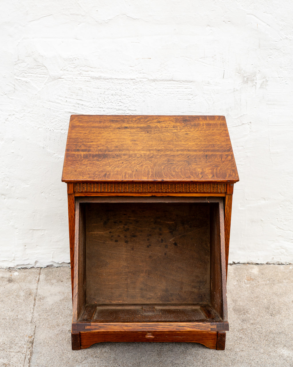 Front view of the oak bin cabinet with the tilt front removed, showing the empty dark interior case.