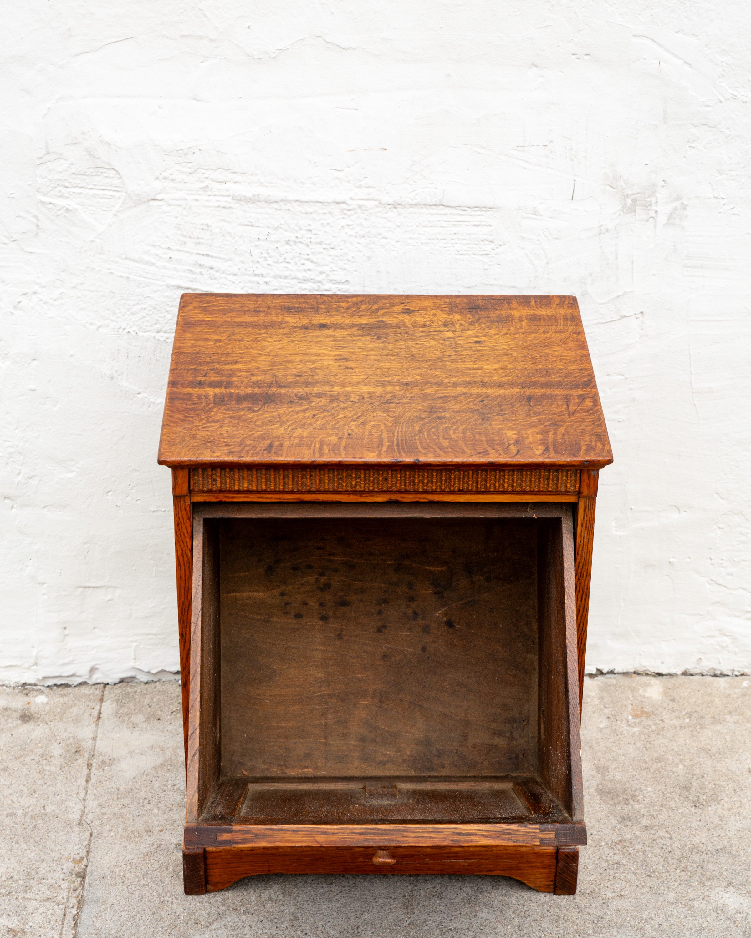 Front view of the oak bin cabinet with the tilt front removed, showing the empty dark interior case.