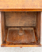 Looking down into the empty case of the oak bin cabinet, showing the unfinished interior floor and back panel.