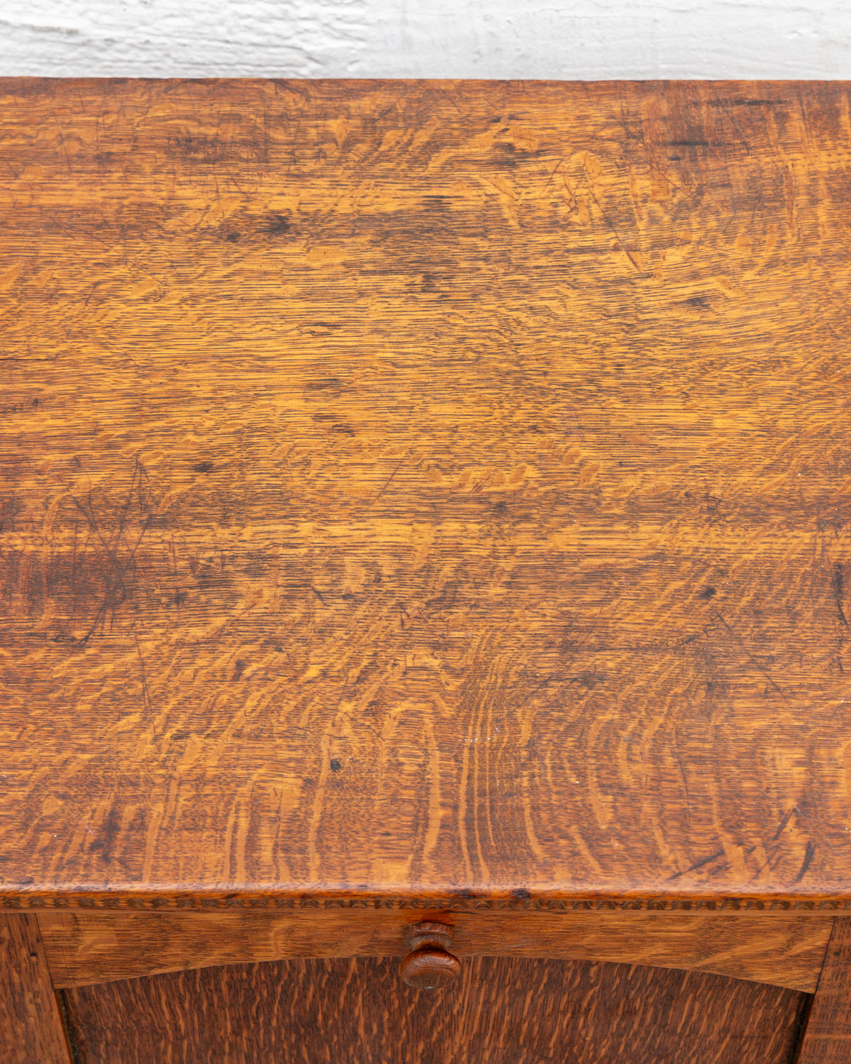 Detail of the cabinet top in quarter-sawn oak, showing heavy ray fleck figure, fine scratches and dark marks.