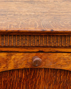 Close detail of the carved thumb molding band and turned wooden knob on the tiger oak bin cabinet.