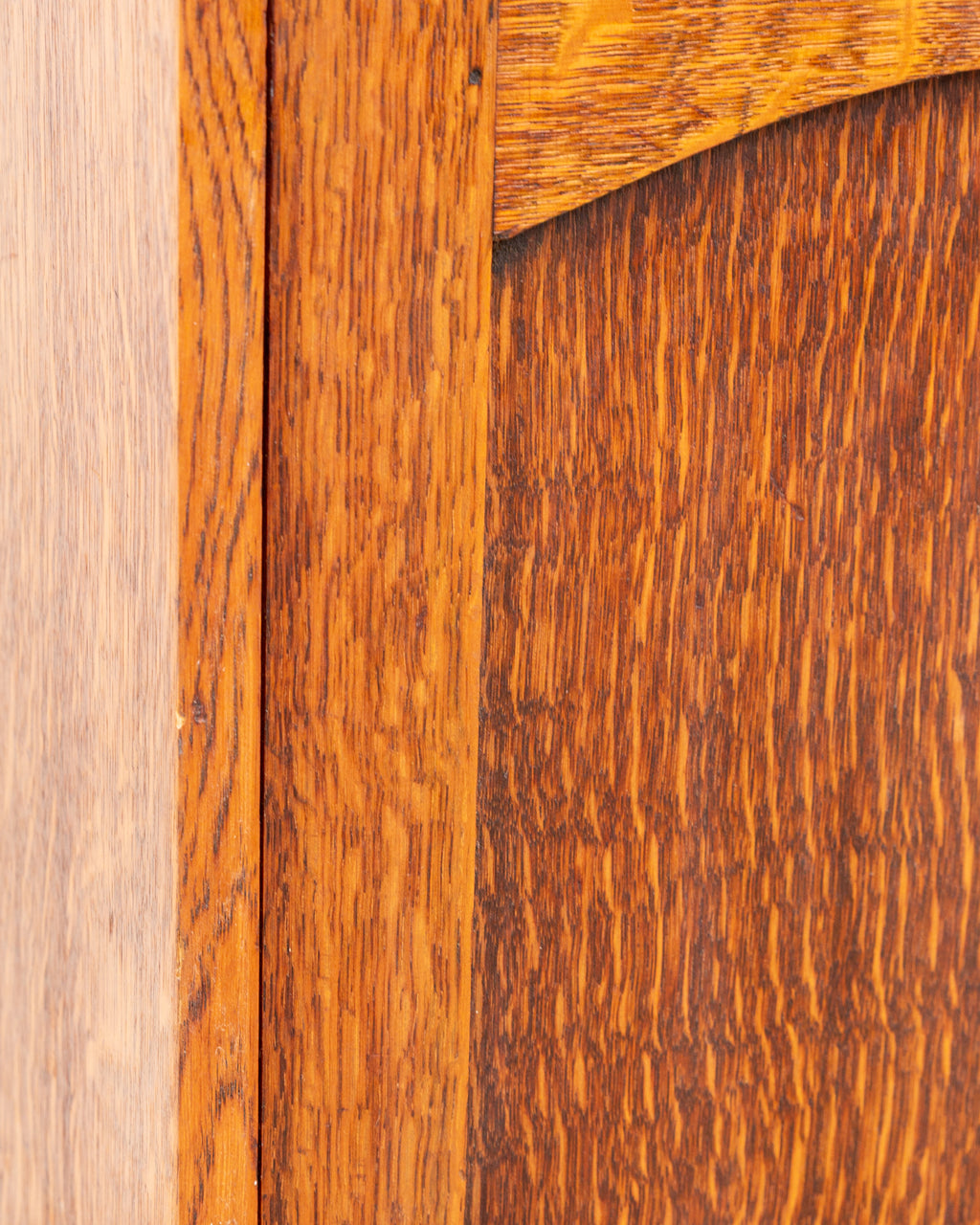 Tight detail of the tiger oak door panel meeting the frame stile, showing dense ray fleck striping.