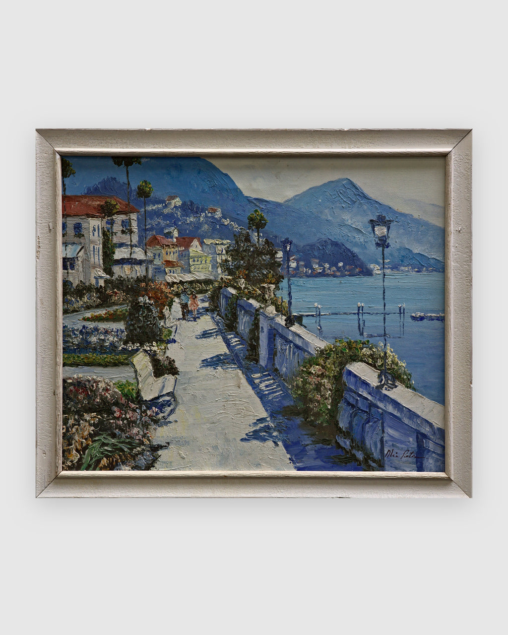 Palette knife painting of a Mediterranean lakeside promenade with villas and blue mountains in a white frame on a light gray background