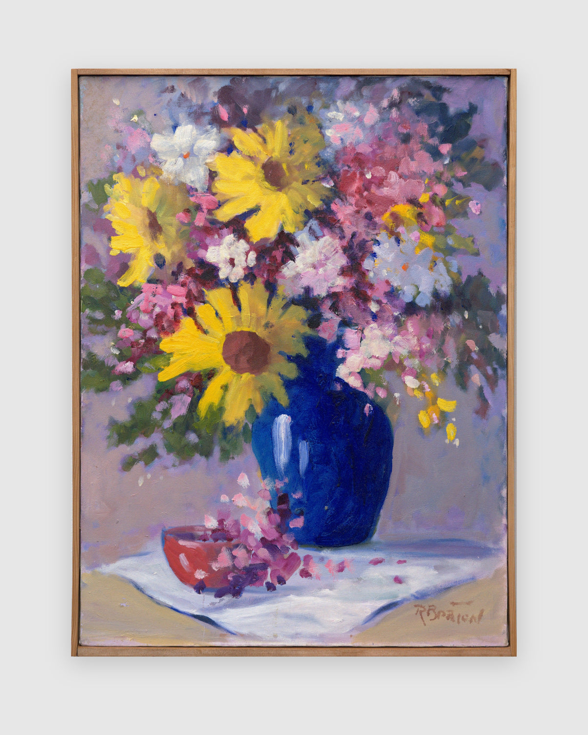 Straight-on view of a vintage impressionist floral still life painting, yellow sunflowers and pink and white blossoms in a cobalt blue vase, in a natural wood strip frame on a light gray background.