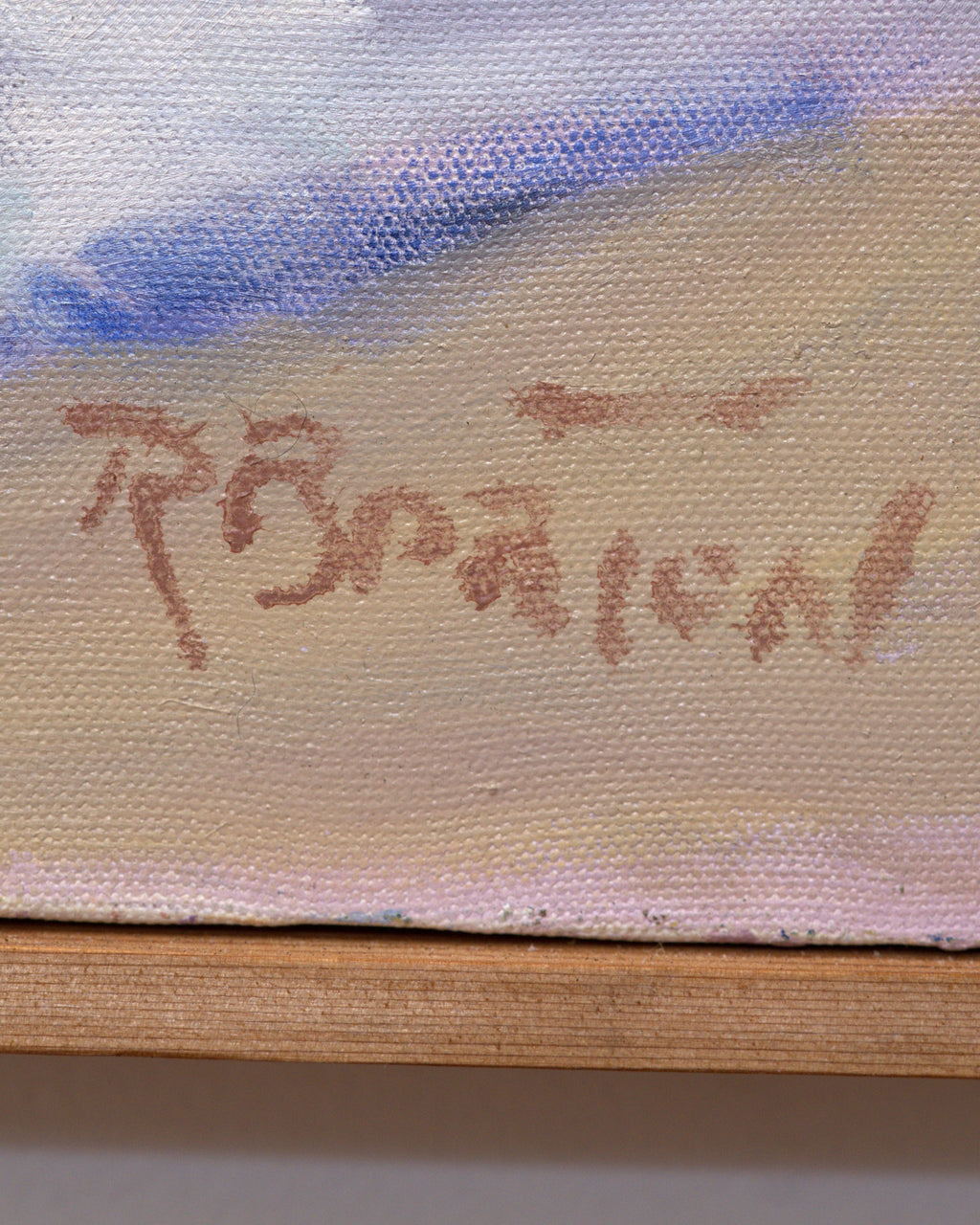 Detail of the artist signature in brown paint at lower right of the floral still life, above the wood frame edge.