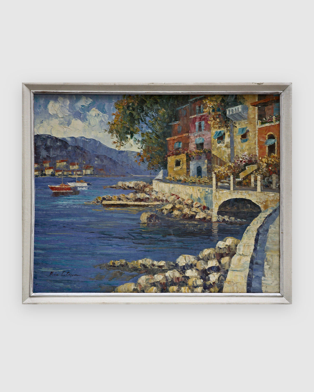 Palette knife oil painting of a Mediterranean harbor with colorful houses and a stone bridge in a white frame on a light gray background