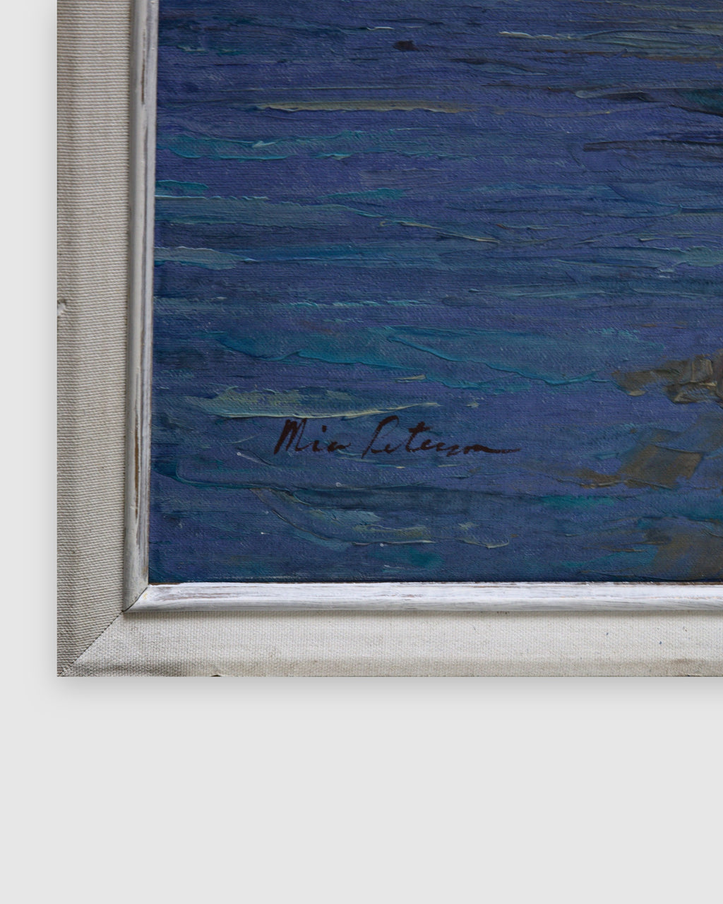 Signature in the lower left corner on deep blue water beside the white frame on a light gray background