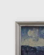 Angled view of the slim white frame along the edge of the harbor painting on a light gray background