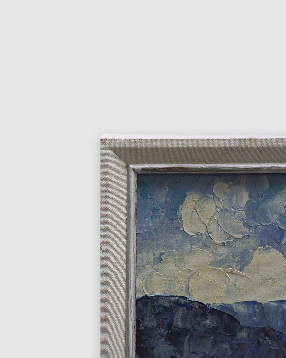 Angled view of the slim white frame along the edge of the harbor painting on a light gray background