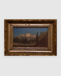 Straight-on view of a small Italian landscape of a hilltop villa and cypresses in a carved gilt and silver frame, on a light gray background.