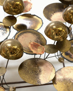 Close detail of brass spheres and cupped discs with torched bronze and near-black patina on the Curtis Jere sculpture.