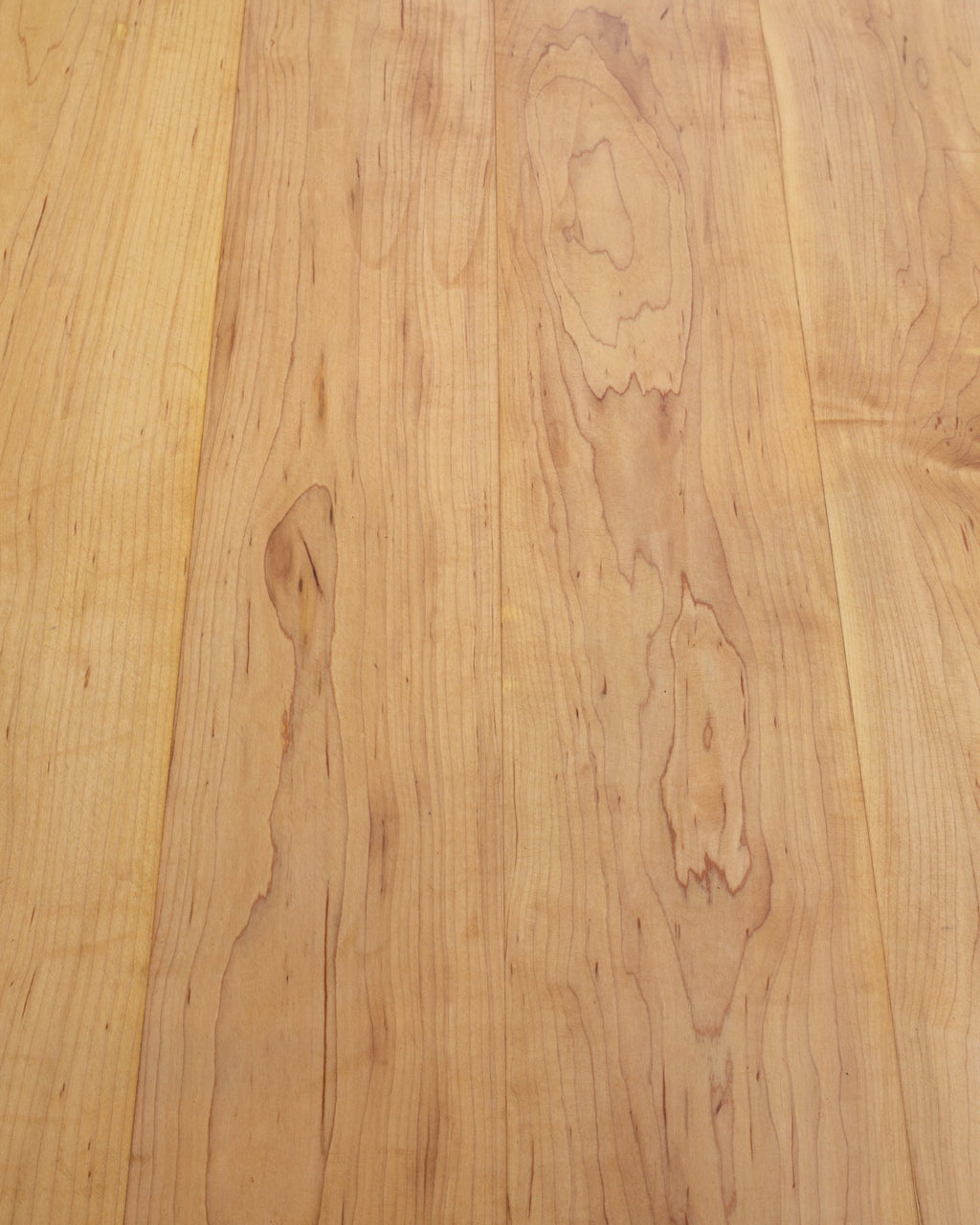 Close view of the grain and board seams on a solid maple tabletop.