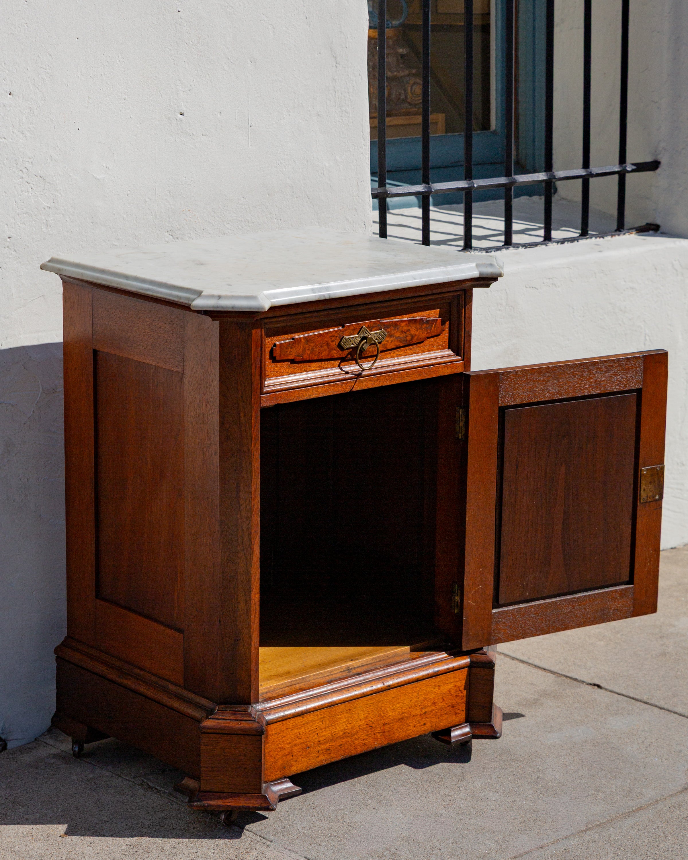 The cabinet with its cupboard door open, showing the plain interior and single fixed shelf