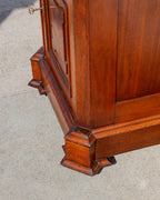 Detail looking down at the base moldings and blocked corner foot of the walnut cabinet