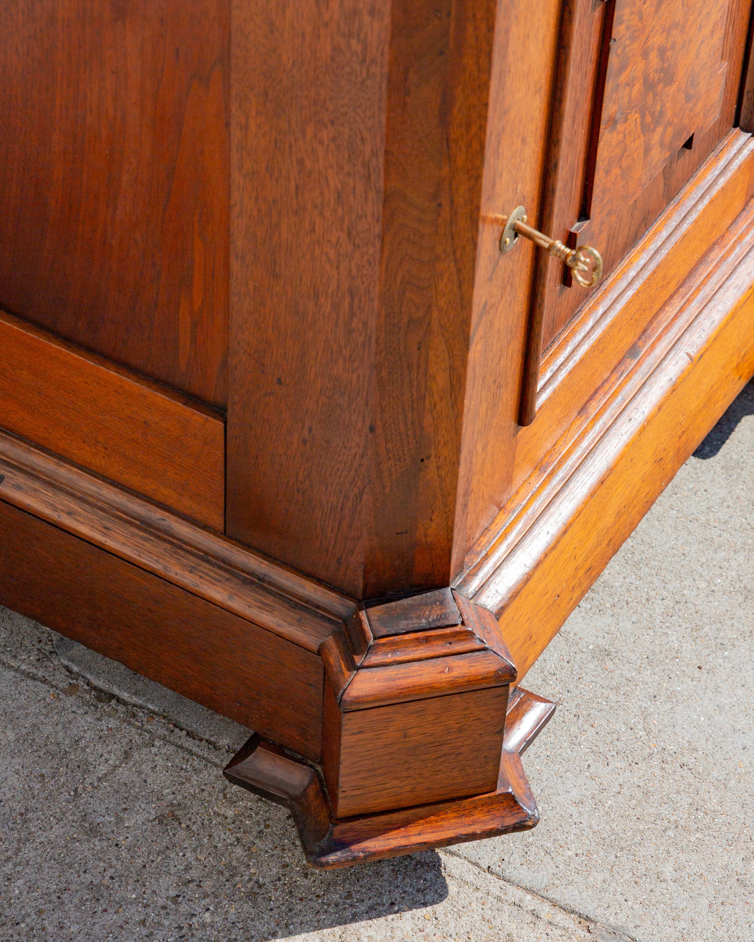 Close detail of the blocked corner foot and stepped base molding in walnut