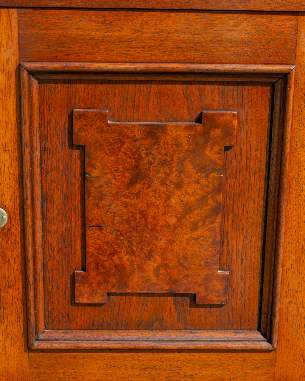 Detail of the applied burl walnut panel on the cupboard door, cut in a stepped Eastlake shape, with a shrinkage split through the burl