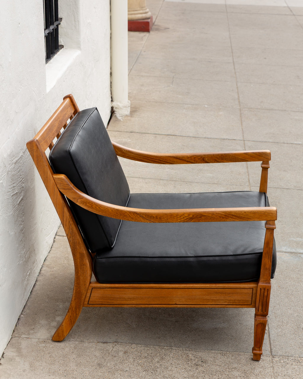 Side profile of the mid century arm chair showing the slatted back rail and the outward sweep of the back leg