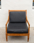 Straight-on front view of the mid century oak arm chair with black seat and back cushions