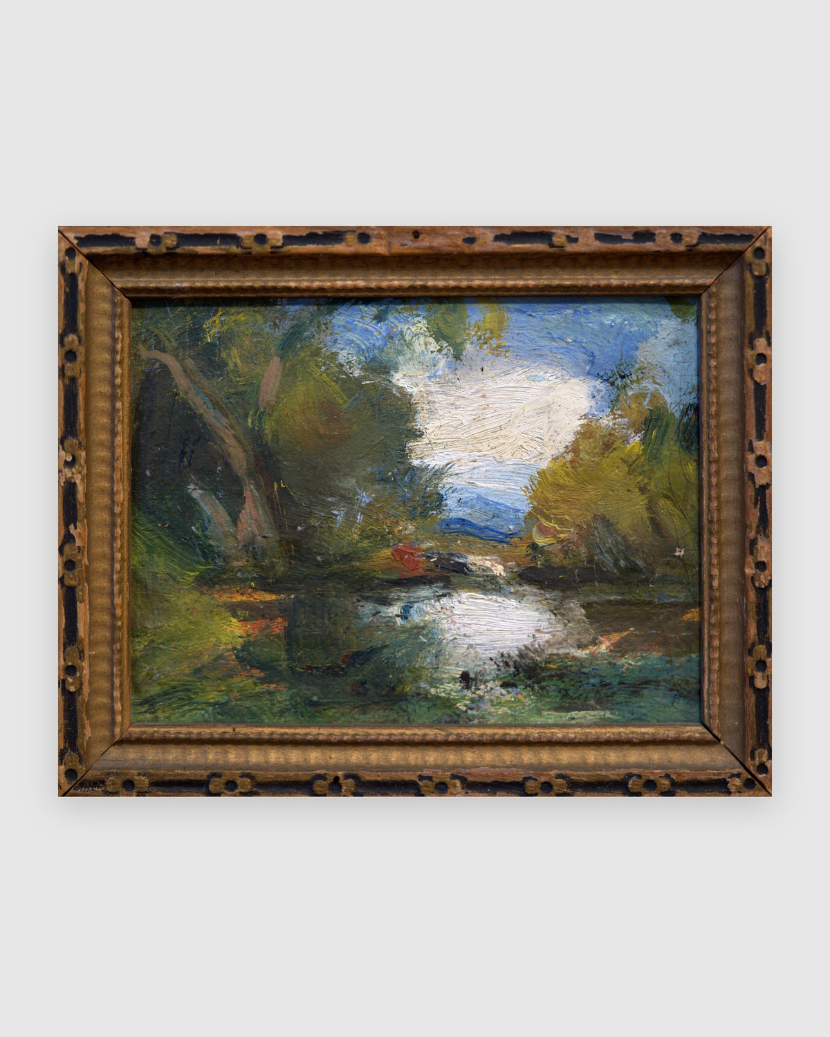 Straight-on view of a miniature impressionist pond landscape in a carved dark gilt frame, on a light gray background.
