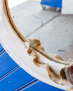 Detail of the inner edge of the white ceramic mirror frame with ruffled amber glazed leaves.
