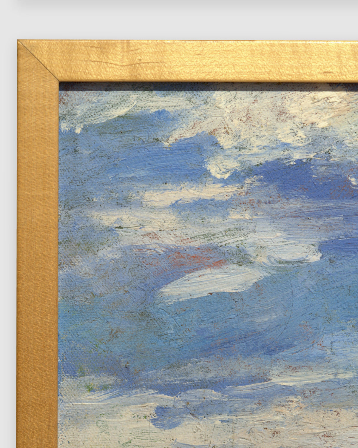 Side view of the frame edge on the John Modesitt painting of a golden coastal bluff and beach near San Diego in a light wood frame.