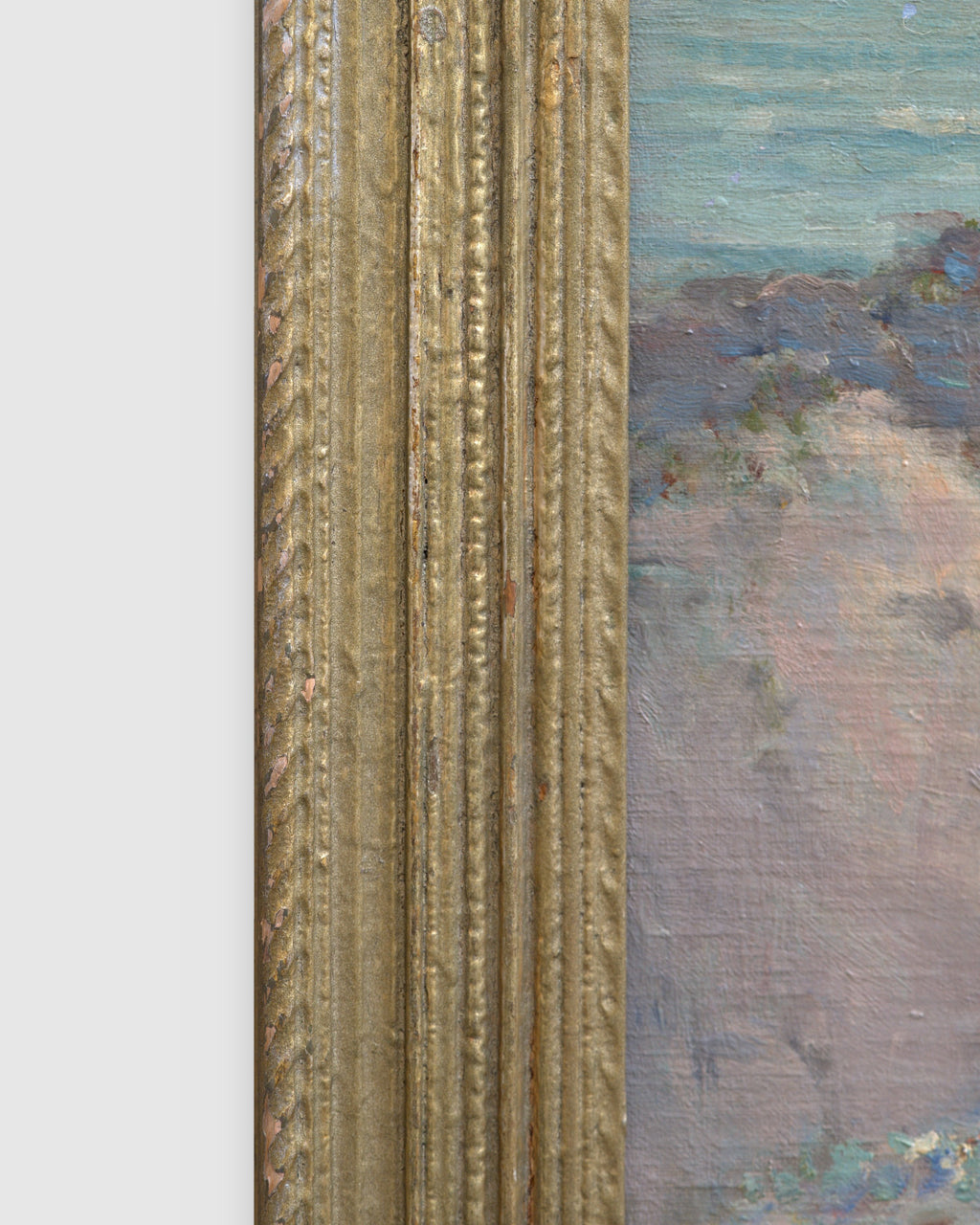 Side view of the frame edge on the Frank Montague Moore painting of sand dunes with blue lupine and a silver sea in a ribbed gilt frame.