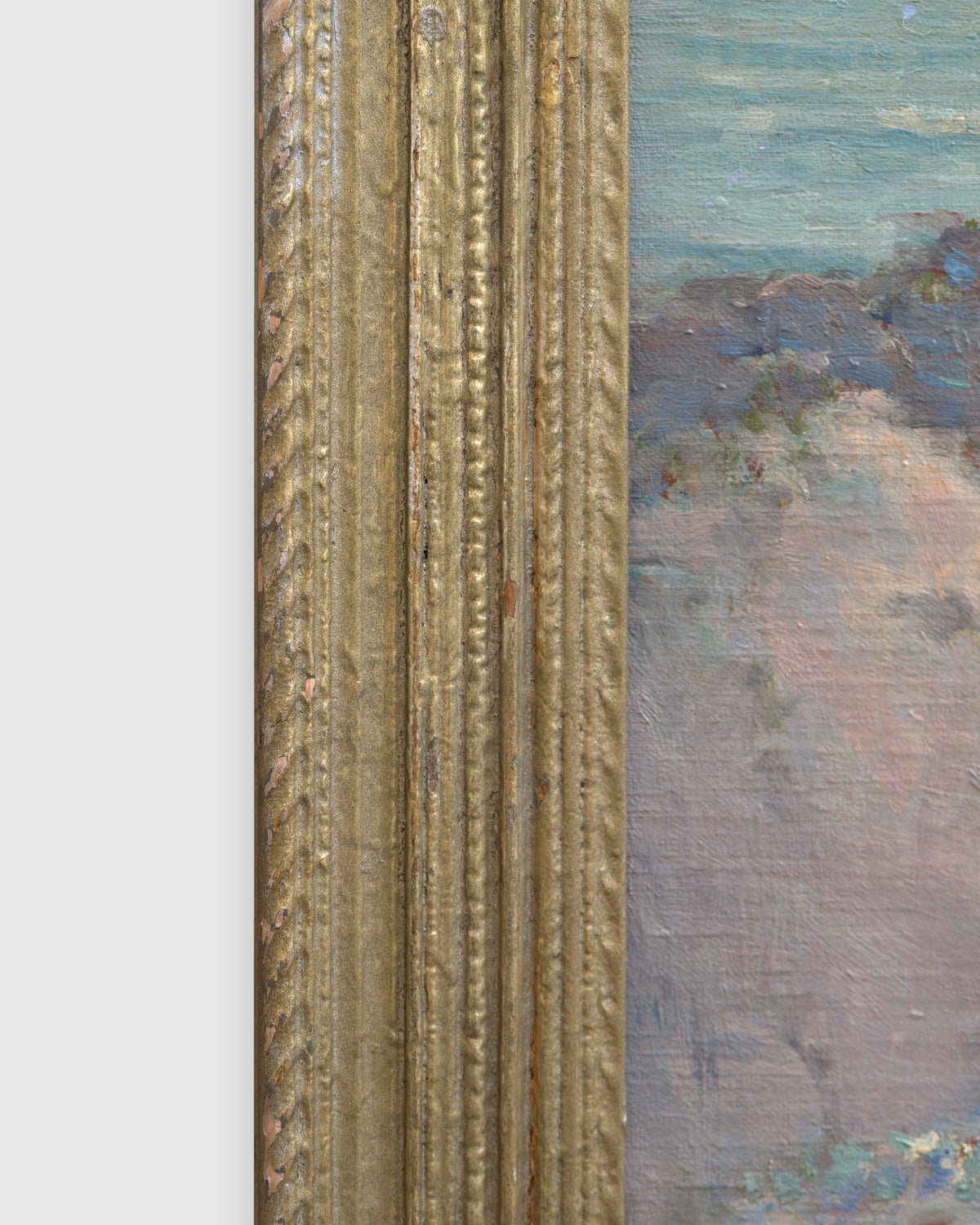 Side view of the frame edge on the Frank Montague Moore painting of sand dunes with blue lupine and a silver sea in a ribbed gilt frame.
