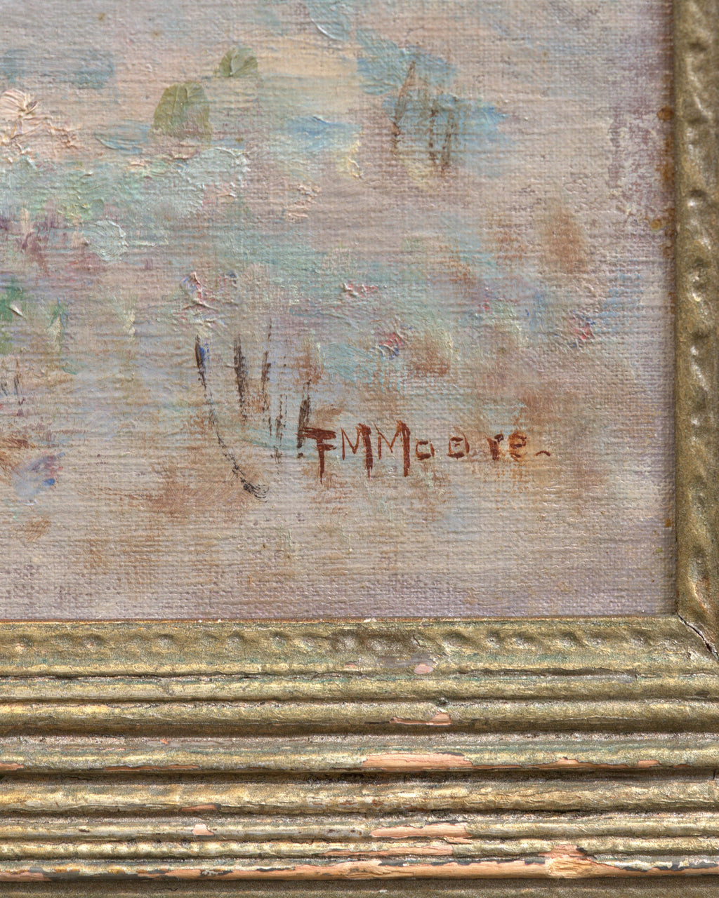 Detail of the signature on the Frank Montague Moore painting of sand dunes with blue lupine and a silver sea in a ribbed gilt frame.