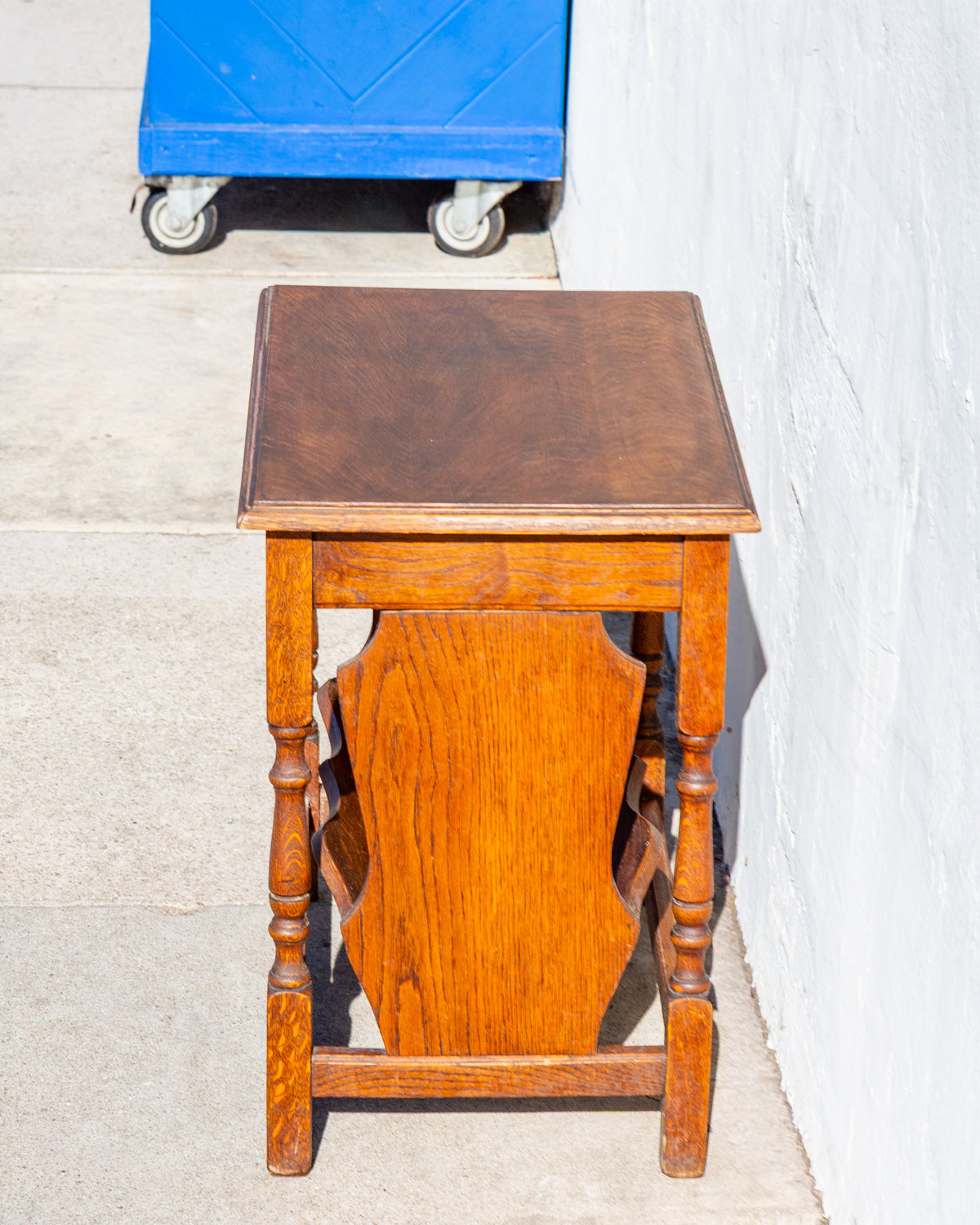 End view of an oak side table with a shaped oak end panel between turned legs