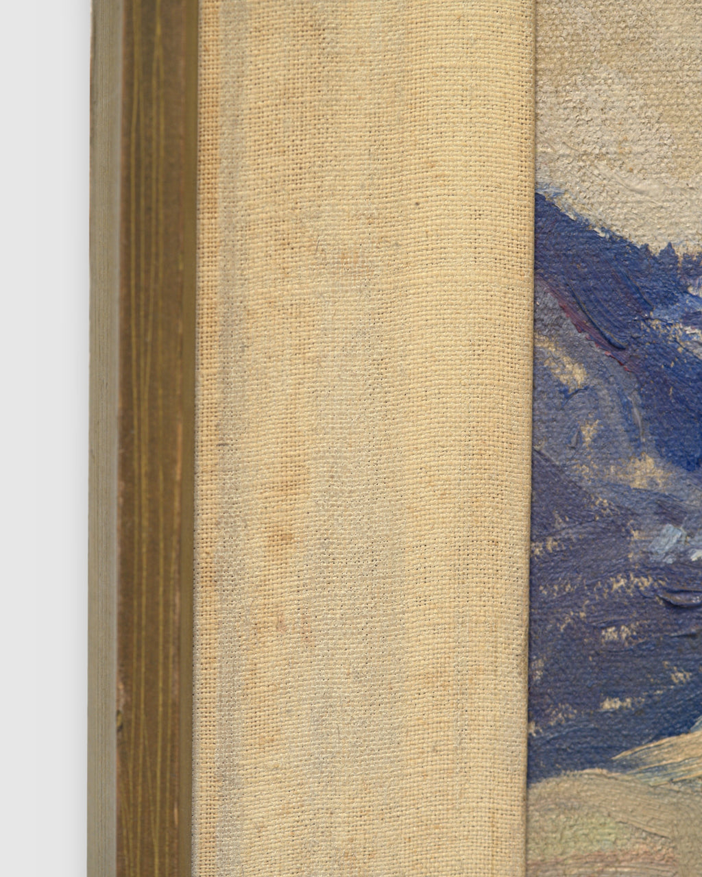 Side view of the frame edge on the Lee Fritz Randolph painting of a blue snow-streaked mountain range above an ochre plain in a natural wood frame.