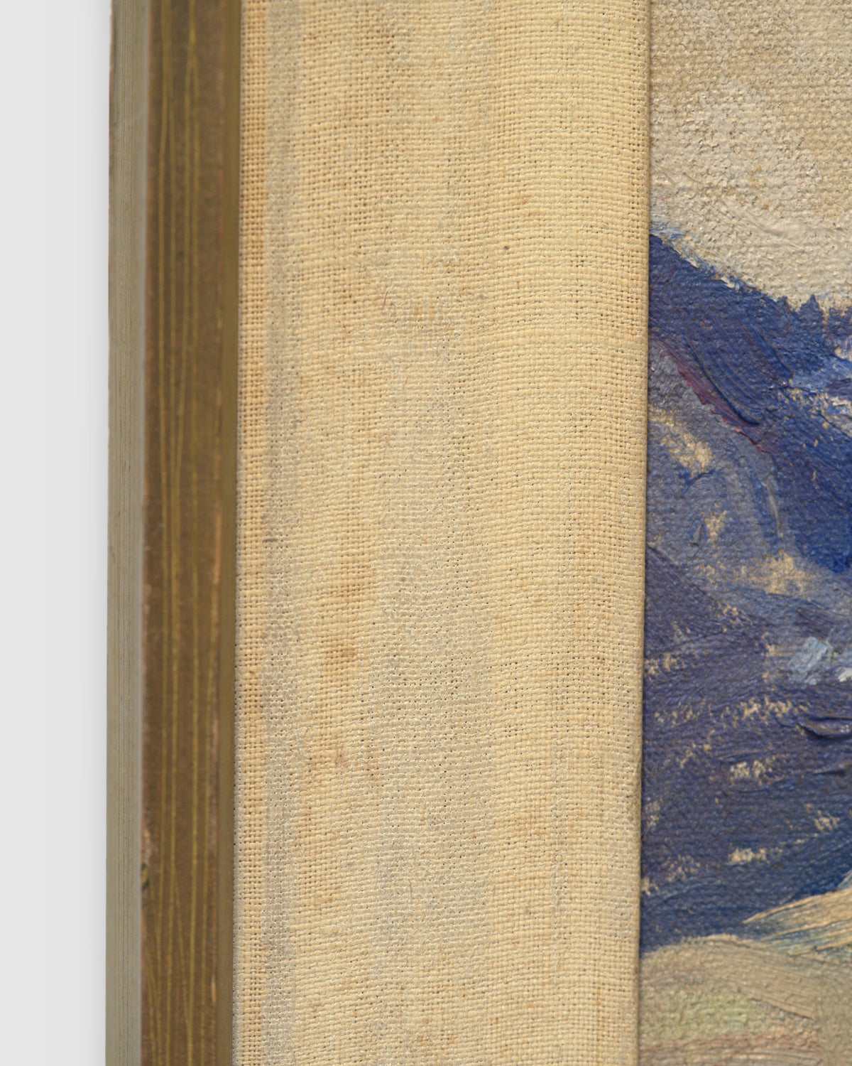 Side view of the frame edge on the Lee Fritz Randolph painting of a blue snow-streaked mountain range above an ochre plain in a natural wood frame.