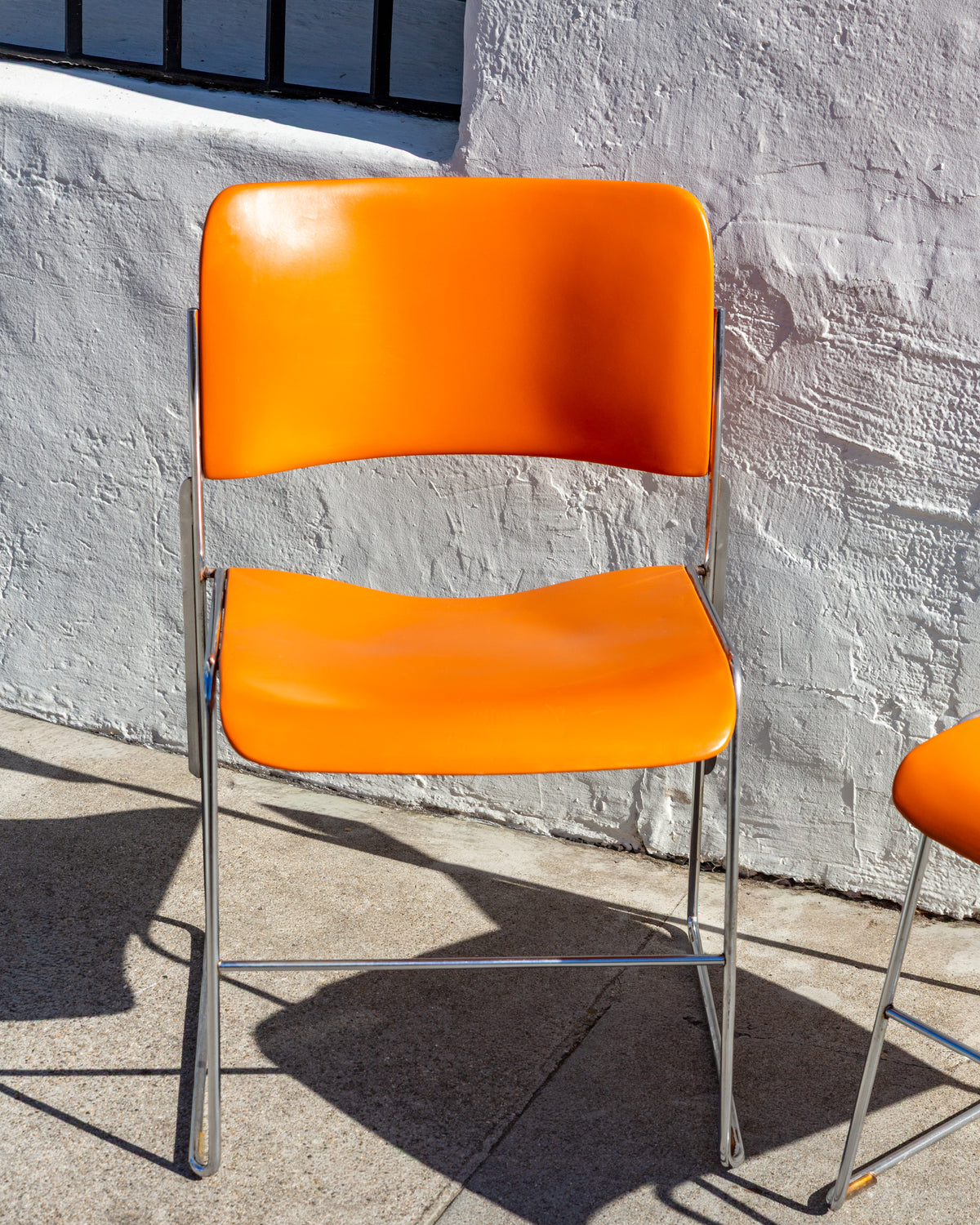 Front view of a single orange David Rowland 40/4 chair with chromed steel frame