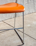 Detail of the orange seat edge, chrome legs and cross stretcher of a 40/4 chair