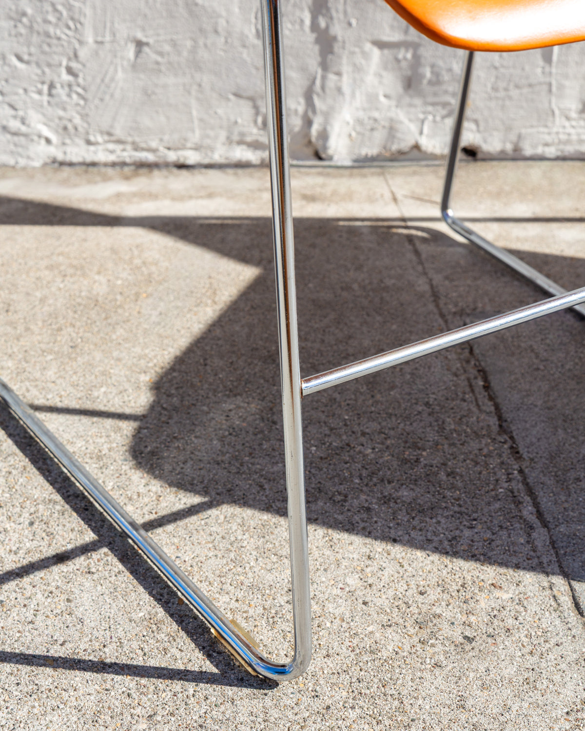 Close-up of the chromed steel rod sled legs and stretcher of a 40/4 stacking chair