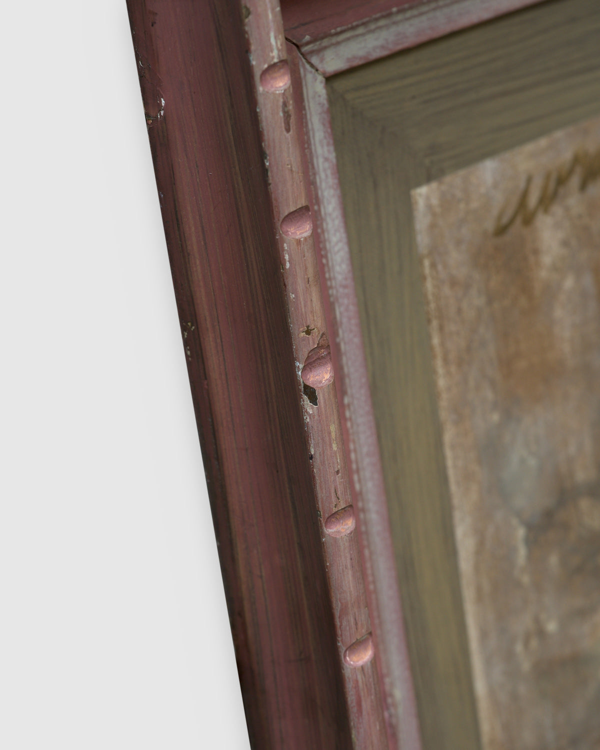 Angled view showing the frame depth of the Avram Rubenstein abstraction of a pale bird in chalky white and rust in a pink bamboo-style frame.