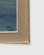 Corner of the frame on the 1960s seascape of turquoise breaking waves, rocks and a misty headland in a whitewashed frame with linen liner.
