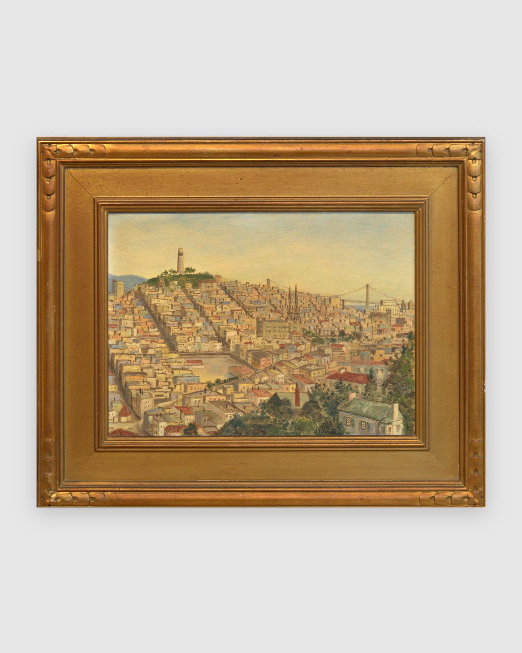 Straight-on view of a vintage San Francisco cityscape painting with Coit Tower and the Bay Bridge in a carved gilt frame, on a light gray background.