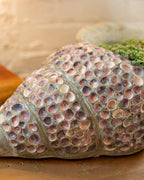 Detail of the spiral ridges and pink shell inlay running toward the tip of a conch planter