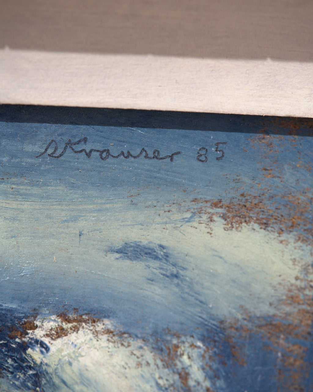 Detail of the signature on the Sterling Strauser 1985 portrait An Actress, a pale face in a blue and white hood, in a whitewashed scored frame.