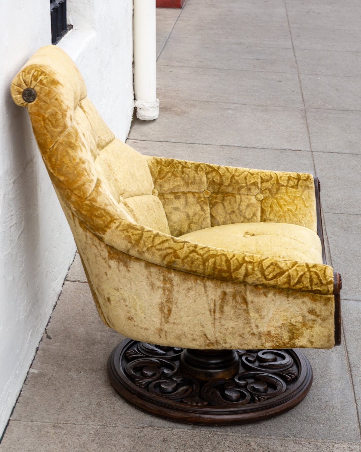 Side profile of the swivel chair showing the long backward sweep of the back and the rolled headrest