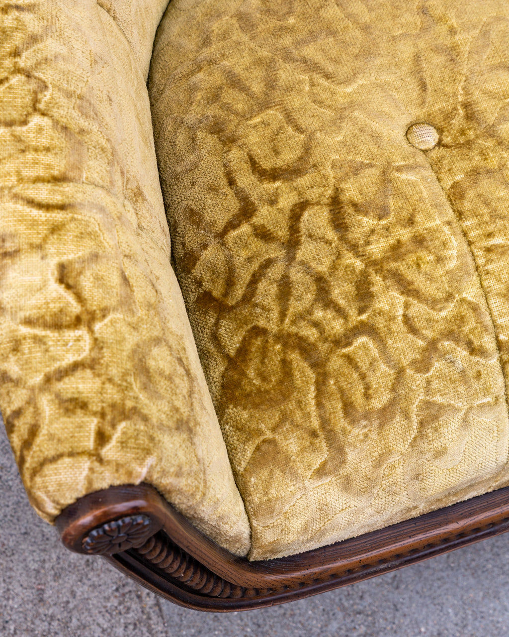 Detail of the seat and back junction in gold velvet, showing one button that has lost its velvet cover